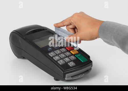 Person Hand swiping Kreditkarte durch Maschine Stockfoto