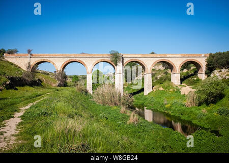 Schöne alte steinerne Brücke der abgebrochenen Bahnübergang ein kleiner Fluss. Region Apulien, Italien