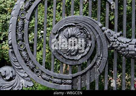 Antik schwarz Gusseisen verzierte Gitter mit staubigen Oberfläche floralen Elementen. Alte Tür Gitter. Die Details der retro Sign-in Moskau, Russland Stockfoto