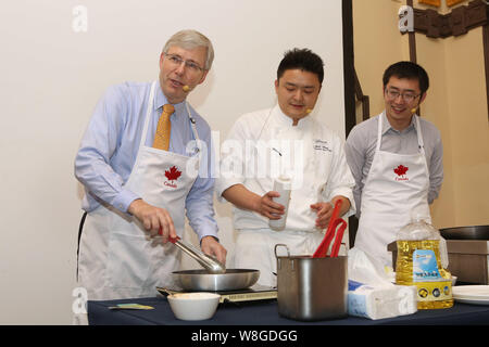 Kanadische Botschafter in China Kerl Saint-Jacques, Links, zeigt seine Kochkünste als Barry Zhu Pengcheng, rechts, Chief Merchandising Officer von yihao Stockfoto