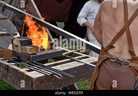 Der Schmied ist ein Meister der Metallverarbeitung. Er schmiedet heißes Metall, und macht die Produkte aus. Stockfoto