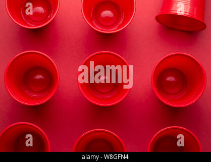 Das Trinken aus Kunststoff Gläser auf rotem Hintergrund Stockfoto