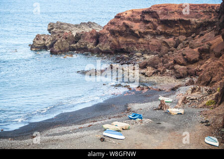 Boote auf der vulkanischen Küste von El Golfo auf der Insel Lanzarote geparkt - Kanarische Inseln Stockfoto