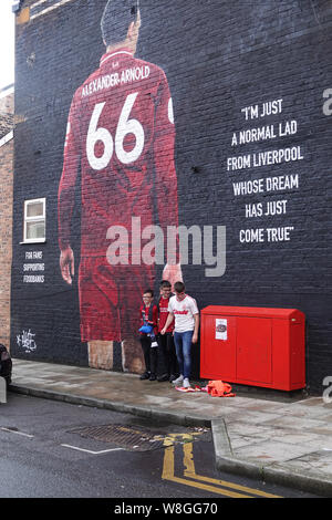 Liverpool, Großbritannien. 9. August 2019. Liverpool fans bewundern Sie die neue Trent Alexander Arnold Wandbild in Sybil Road in der Nähe der Boden vor dem ersten Heimspiel der Saison 2019-2020 gegen Norwich in Liverpool. Von französischen Graffiti Künstler Akse gemalt, und von Liverpool FC fan Podcast der Anfield Wrap angeordnet. Das wandbild ist für Fans Unterstützung Foodbank, eine lokale Initiative, die vom Geist der Shankly und Everton Unterstützer Vertrauen gegründet Essen Armut im Norden von Liverpool zu bekämpfen. Credit: Ken Biggs/Alamy Leben Nachrichten. Stockfoto