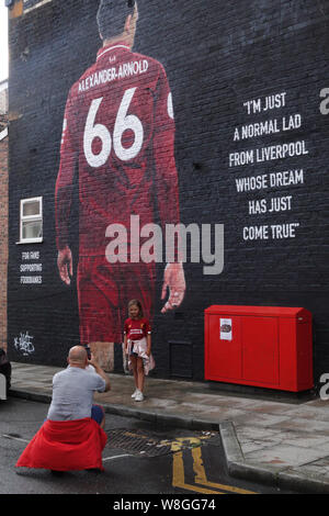 Liverpool, Großbritannien. 9. August 2019. Liverpool fans bewundern Sie die neue Trent Alexander Arnold Wandbild in Sybil Road in der Nähe der Boden vor dem ersten Heimspiel der Saison 2019-2020 gegen Norwich in Liverpool. Von französischen Graffiti Künstler Akse gemalt, und von Liverpool FC fan Podcast der Anfield Wrap angeordnet. Das wandbild ist für Fans Unterstützung Foodbank, eine lokale Initiative, die vom Geist der Shankly und Everton Unterstützer Vertrauen gegründet Essen Armut im Norden von Liverpool zu bekämpfen. Credit: Ken Biggs/Alamy Leben Nachrichten. Stockfoto