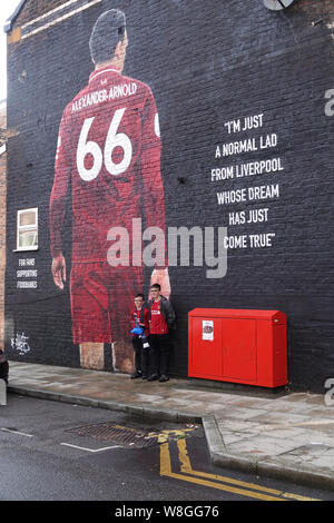 Liverpool, Großbritannien. 9. August 2019. Liverpool fans bewundern Sie die neue Trent Alexander Arnold Wandbild in Sybil Road in der Nähe der Boden vor dem ersten Heimspiel der Saison 2019-2020 gegen Norwich in Liverpool. Von französischen Graffiti Künstler Akse gemalt, und von Liverpool FC fan Podcast der Anfield Wrap angeordnet. Das wandbild ist für Fans Unterstützung Foodbank, eine lokale Initiative, die vom Geist der Shankly und Everton Unterstützer Vertrauen gegründet Essen Armut im Norden von Liverpool zu bekämpfen. Credit: Ken Biggs/Alamy Leben Nachrichten. Stockfoto