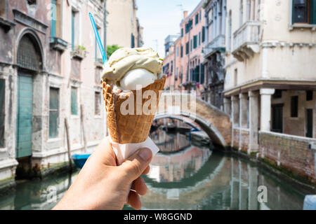 Nahaufnahme einer Hand, die Eiscreme Kegel auf Venedig Straße Stockfoto