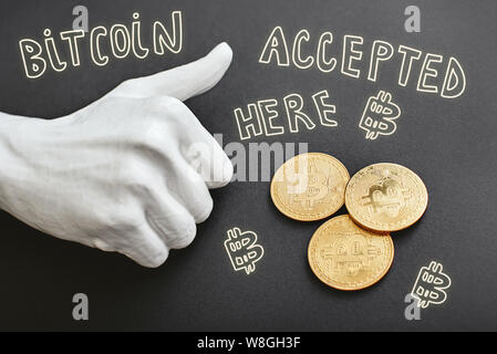 Haufen Bitcoins auf schwarzem Hintergrund isoliert. Handgezeichnete Doodle-Illustration 'Bitcoin accepted here' und Daumen nach oben daneben. Digitales Währungskonzept. Horizontale Aufnahme Stockfoto