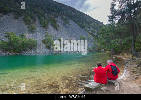 Touristen auf See Bank eines Lochan Uaine im Glenmore Forest Park, Cairngorms National Park in der Nähe von Aviemore, Badenoch und Strathspey, Schottland, Großbritannien Stockfoto