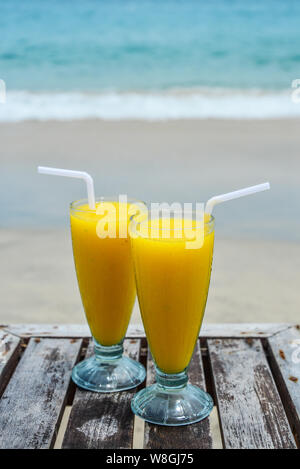 Iced Glas mit Mango smoothies am Strand auf der Insel Bali Stockfoto
