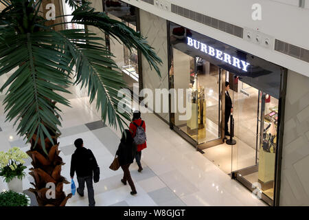 ------ Kunden vorbei an einem Burberry Store in der Shopping Mall in Shanghai, China, 3. Dezember 2014. Modehaus Burberry Group PLC berichtet Bette Stockfoto