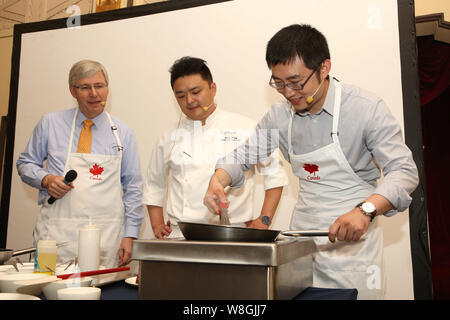 Barry Zhu Pengcheng, rechts, Chief Merchandising Officer von Yihaodian.com, seine Kochkünste als kanadischer Botschafter in China Kerl Saint-Jacqu Stockfoto