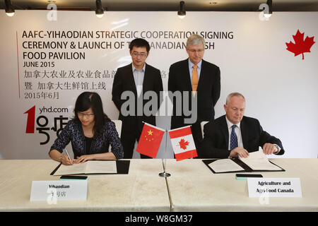 Barry Zhu Pengcheng, hinten links, Chief Merchandising Officer von Yihaodian.com, und der kanadische Botschafter in China Kerl Saint-Jacques, hinten rechts, t teilnehmen Stockfoto