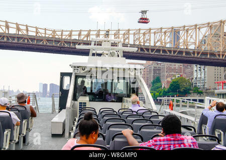 NYC East River Ferry und Roosevelt Island Tramway über den East River und die Skyline von New York bei Sonnenuntergang. New York City, USA. Stockfoto