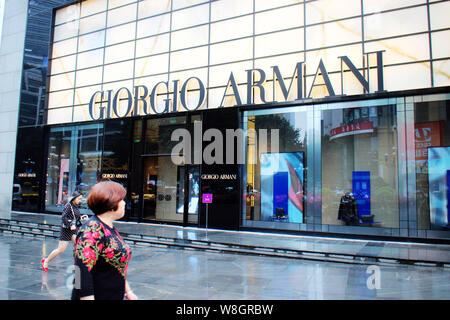 ---- Fußgänger vorbei eine Boutique von Giorgio Armani in Chongqing, China, 11. Oktober 2015. Trotz stagnierender Umsätze von Luxusgütern bei Ho Stockfoto