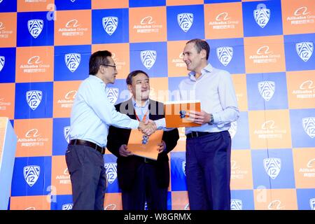 Joseph Tsai, Links, Mitbegründer und Executive Vice Chairman der Alibaba Group, schüttelt Hände mit Pac-12 Kommissar Larry Scott, Rechts, an einer Presse Konferenz Stockfoto