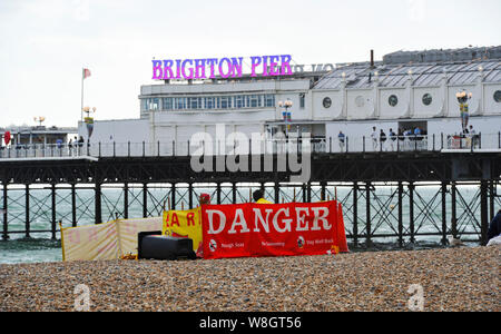 Brighton, UK. 9 Aug, 2019. Brighton Rettungsschwimmer mit ihren roten Gefahr Warnschild am Strand als ungewöhnlich nassen und windigen Wetter breitet sich über Teilen des Vereinigten Königreichs an diesem Abend mit Netzteile erwartet beeinflußt zu werden. Foto: Simon Dack/Alamy leben Nachrichten Stockfoto