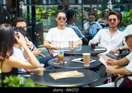 Jungen asiatischen nach Freunden entspannen im freien Kaffee shop Stockfoto