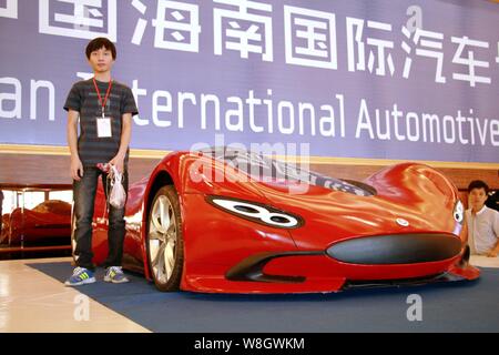 Junge Chinesen Chen Yinxi, Links, stellt mit seinen hausgemachten elektrischen Sportwagen auf dem Display während der 2015 Hainan Internationale Automobil Ausstellung Stockfoto
