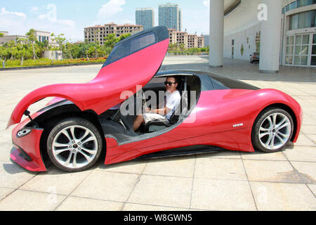 Ein Mann versucht, das hausgemachte elektrischen Sportwagen erstellt von jungen Chinesen Chen Yinxi auf Hainan Exhibition & Convention Center in Hai Stockfoto