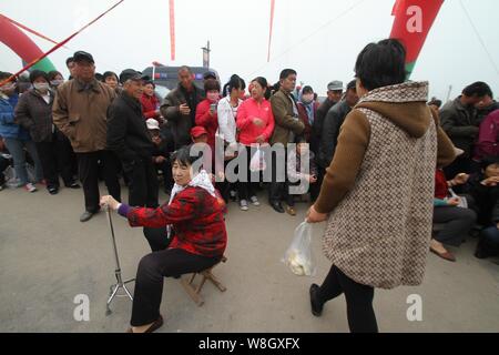 Lokale chinesische Bewohner Warteschlange frei, Reis und Öl während einer Werbeveranstaltung von einer Firma in Binzhou Stadt, East China ¯ s der Provinz Shandong, 3 M Stockfoto