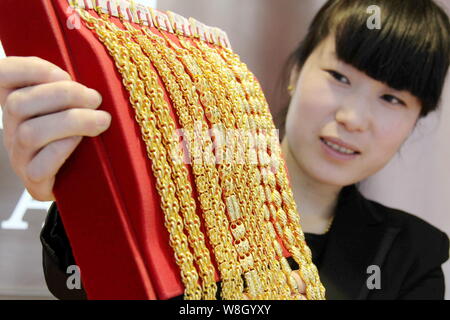 ---- Eine chinesische Angestellte zeigt Gold Halsketten an einem Juwelier in Rizhao Stadt, im Osten der Provinz Shandong, China, 23. Februar 2015. China durchgeführt tr Stockfoto