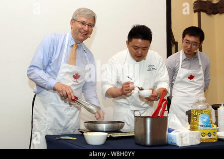 Kanadische Botschafter in China Kerl Saint-Jacques, Links, zeigt seine Kochkünste als Barry Zhu Pengcheng, rechts, Chief Merchandising Officer von yihao Stockfoto