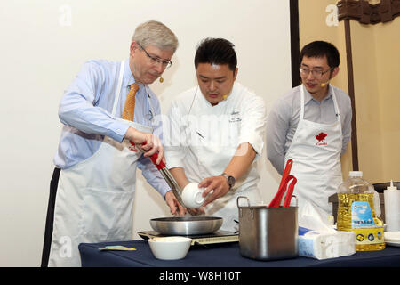 Kanadische Botschafter in China Kerl Saint-Jacques, Links, zeigt seine Kochkünste als Barry Zhu Pengcheng, rechts, Chief Merchandising Officer von yihao Stockfoto