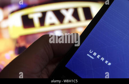 ---- Ein Mann mit dem Taxi - hageln app Uber auf seinem Smartphone in Jinan, Provinz Shandong, China, 6. Mai 2015. Die südchinesische Stadt Stockfoto