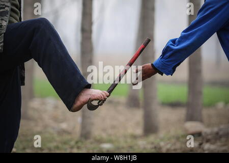 Armlose Chinese Jia Wenqi, links, mit seinem Fuß eine reaphook zu seinem blinden Freund Jia Haixia in Yeli Dorf, Jingxing County, Shijiazhuang ci Stockfoto