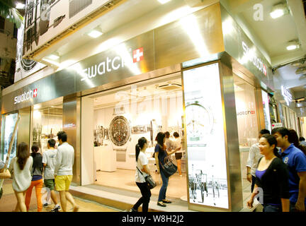 ---- Fußgänger vorbei an eine Swatch Store in Hongkong, China, 12. Oktober 2013. Swatch Group AG ein in ersten 20% drop-hälfte Profit auf Thursd Stockfoto