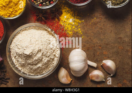 Getrockneten Knoblauch. Für Text platzieren. Verschiedene Arten von Gewürzen in einer Schüssel auf einem Stein. Der Blick von oben Stockfoto