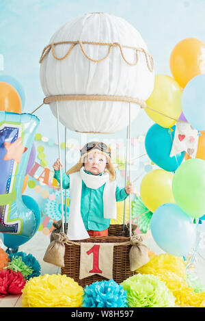 Dekoration für erste Boy's Geburtstag, smash Kuchen in einem aviator Stil. Kind lächeln in die Kamera zu schauen. Portrait von adorable kaukasische Baby Boy celebratin Stockfoto