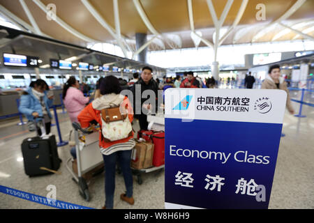 ---- Passagiere Schlange in Neben einem Namensschild von China Southern Airlines am internationalen Flughafen Shanghai Pudong in Shanghai, China zu prüfen. Stockfoto