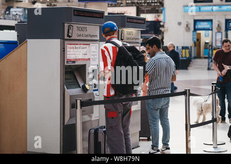 London, Großbritannien - 16 Juli, 2019: die Menschen Bahn-tickets aus einer Self-service-Maschine in Victoria Bahnhof, einer der belebtesten Bahnhöfen Stockfoto