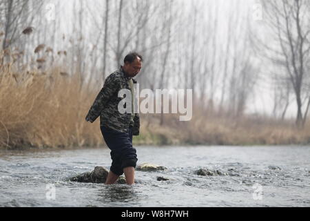 Armlose Chinese Jia Wenqi Spaziergänge über einen Fluss in Yeli Dorf, Jingxing County, Shijiazhuang, Provinz Hebei, North China vom 16. März 2015. Stockfoto