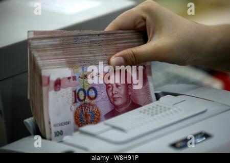 ---- Eine chinesische Angestellte verwendet eine Cash - Zählmaschine RMB (Renminbi) Yuan Banknoten bei einer Bank in der Stadt Huaibei zu zählen, der ostchinesischen Provinz Anhui, 26. Stockfoto