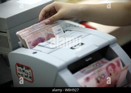---- Eine chinesische Angestellte verwendet eine Cash - Zählmaschine RMB (Renminbi) Yuan Banknoten bei einer Bank in der Stadt Huaibei zu zählen, der ostchinesischen Provinz Anhui, 26. Stockfoto