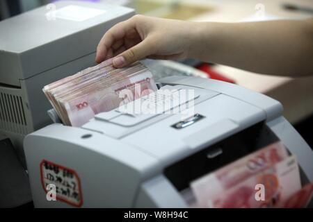 ---- Eine chinesische Angestellte verwendet eine Cash - Zählmaschine RMB (Renminbi) Yuan Banknoten bei einer Bank in der Stadt Huaibei zu zählen, der ostchinesischen Provinz Anhui, 26. Stockfoto