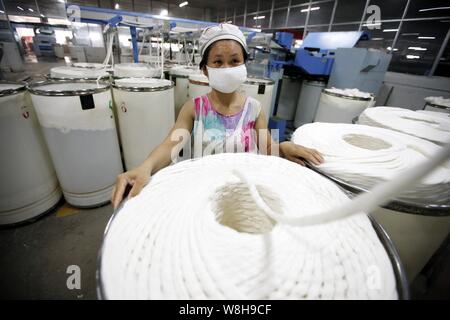 ---- Eine weibliche chinesischer Arbeiter übernimmt Produktion von Garn in einer Textilfabrik in Stadt Huaibei, der ostchinesischen Provinz Anhui, 1. Juli 2015. China ¯ s e Stockfoto