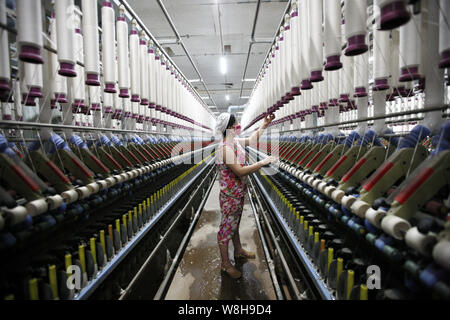 Ein weiblicher chinesischer Arbeiter übernimmt Produktion von Garn in einer Textilfabrik in Stadt Huaibei, der ostchinesischen Provinz Anhui, 1. Juli 2015. Chinas herstellerspez. Stockfoto