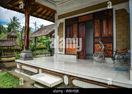 BALI, Indonesien - Januar 9, 2018: Traditionelles balinesisches Haus, Veranda mit Vintage Zyklus auf Bali, Indonesien Stockfoto