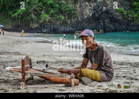 BALI, Indonesien - Januar 14, 2018: Alter Mann spielt eine traditionelle balinesische Instrument gambang am White Sand Beach, Bali, Indonesien Stockfoto