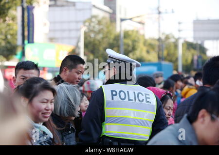 ---- Ein chinesischer Polizist wacht in einer Menschenmenge von Fußgängern auf einer Straße in Shanghai, China, 1. Januar 2015. China hat ein pl genehmigt Stockfoto