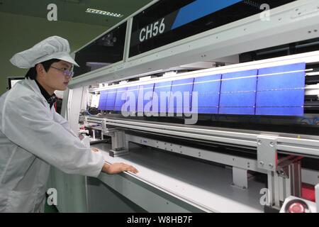 ---- Eine weibliche chinesischer Arbeiter überwacht die Produktion von Solarzellen für Solarmodule zu Europa im Werk Shanghai Shenzhou exportiert werden Stockfoto