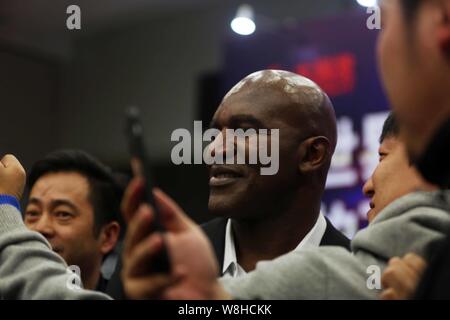 Amerikanischer Box-Weltmeister Evander Holyfield, Mitte, wirft mit chinesischen Mitarbeiter für selfies auf einer Pressekonferenz und Vertragsunterzeichnung Ereignis zu werden Stockfoto