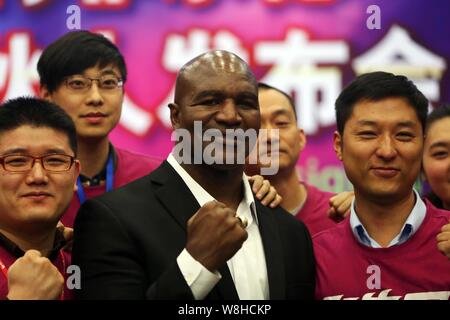 Amerikanischer Box-Weltmeister Evander Holyfield, Mitte, wirft mit chinesischen Mitarbeiter bei einer Pressekonferenz und signaturereignis ein Senior VIP zu werden Stockfoto