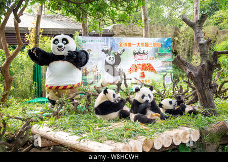Die panda Drillinge Meng Meng, Shuai Shuai und Ku Ku essen Neben einem Entertainer als Po vor einem Plakat für den Film "Kung Fu Panda 3' gekleidet Stockfoto