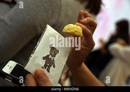 Ein Kunde versucht, eine Butter cookie am JENNY Bäckerei in der Globalen Harbour Einkaufszentrum in Putuo District, Shanghai, China, 25. Oktober 2015. Stockfoto