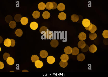 Verschwommen defokussierten Fairy light Glitter von Weihnachtsbeleuchtung auf dunklem Hintergrund Stockfoto